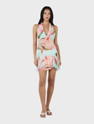 A model wears the Delilah Scarf Top in Bloom Drift Aqua, a floral print dress with a vibrant and stylish appearance.