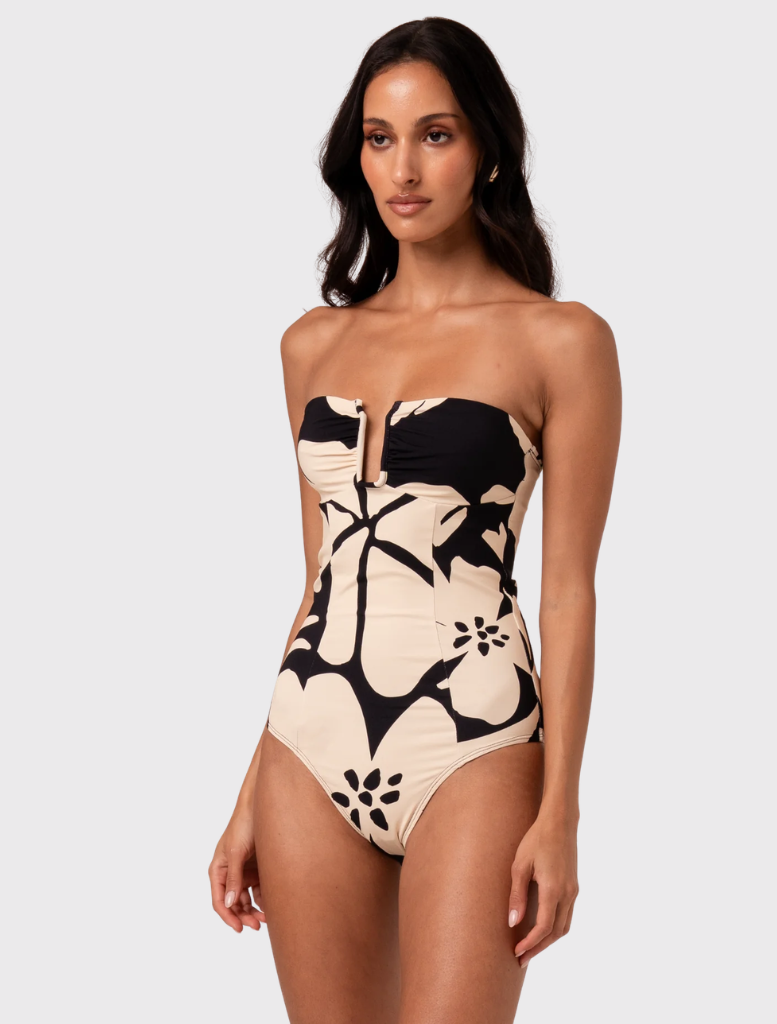 One-piece bathing suit with removable straps, structured bust, and gold hardware, designed in a stylish cream and black pattern.