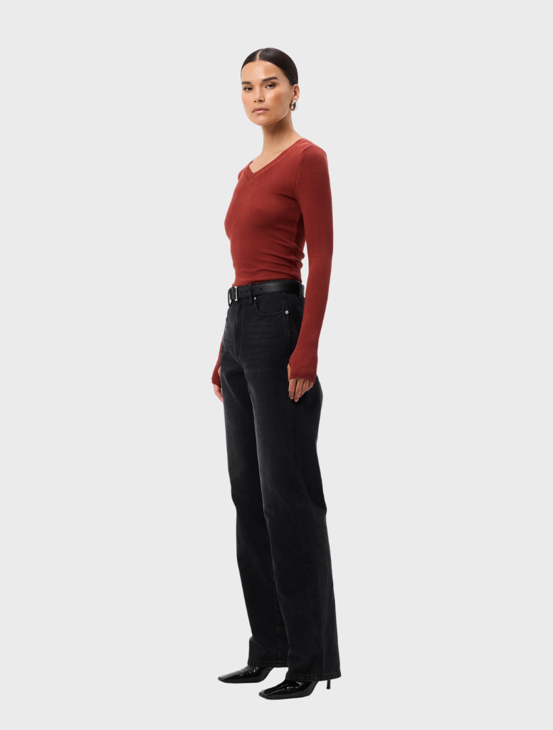 The Sedona Top in rust, featuring a loose silhouette and short sleeves, presented on a model against a neutral background.