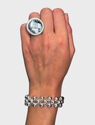 A silver ring featuring beads, showcasing the elegant design of the Clover Bracelet.