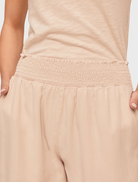 Relaxed fit wide-leg pants in linen sand, featuring a smocked waist for added comfort and a stylish look.