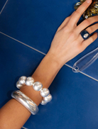 A silver bracelet composed of many round beads, highlighting a contemporary and stylish accessory.