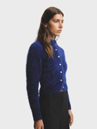 Navy Bella Cashmere Cardigan displayed on a hanger, showcasing its soft texture and elegant design.