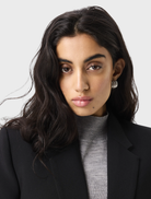 Black Sonder Blazer hanging, designed with a fitted silhouette, perfect for business attire or upscale events.