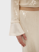 Nadine's pearl pink sequin top, showcasing a sparkling surface and elegant style, perfect for special events or nights out.