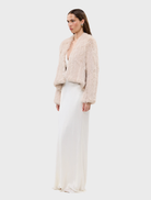 Stone Emma fur jacket on a hanger, featuring a chic design and soft, inviting material.