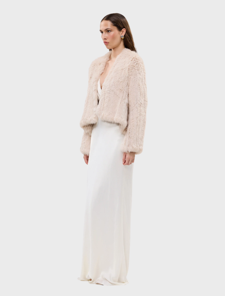 Stone Emma fur jacket on a hanger, featuring a chic design and soft, inviting material.