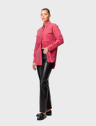 A red striped Tudor shirt folded neatly, featuring distinct stripes and a refined appearance.