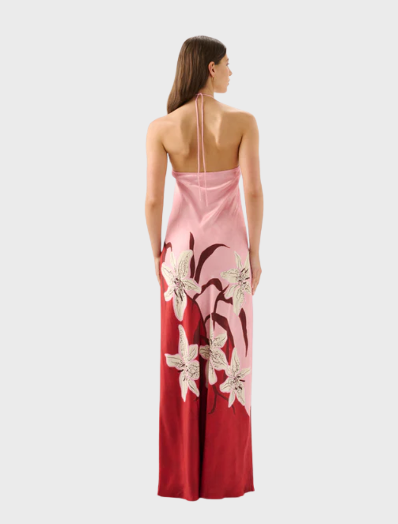 The Liliana Tallulah Halter Dress is worn by a model, featuring a floral pattern in pink and red hues.