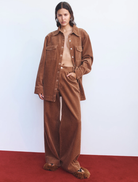 A pair of tan Max Cord Pants laid flat, highlighting the corduroy fabric and tailored fit.
