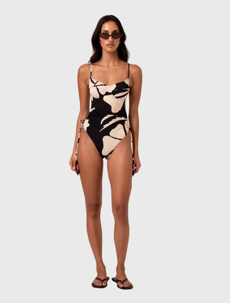 Thin strap underwire one-piece swimsuit in Botanica print, featuring adjustable side ties and a sweetheart neckline for custom fit.