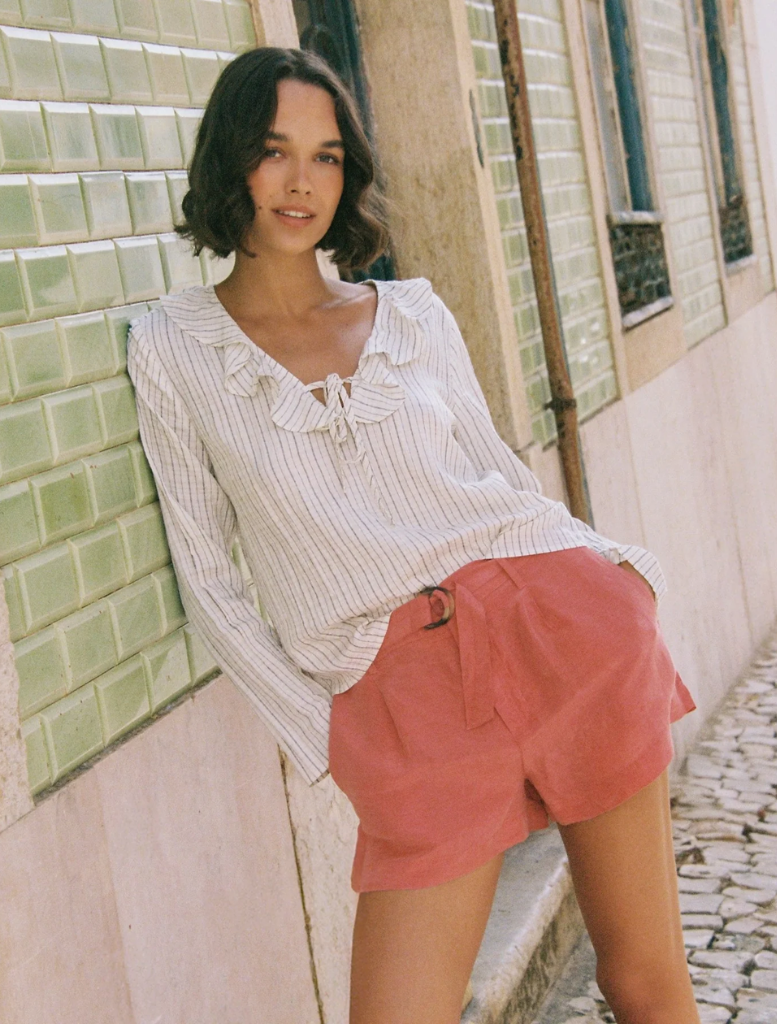 Stylish ecru and black pinstripe top with a ruffle tie neck, ideal for both office and casual settings.