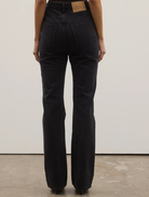 Backstage view of Tilly Bootleg Jean, highlighting its unique cut and fabric against a backdrop of fashion event preparations.