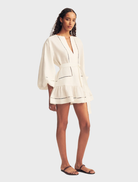 Ivory mini dress designed with balloon sleeves and a playful hem, suitable for various social events and gatherings.