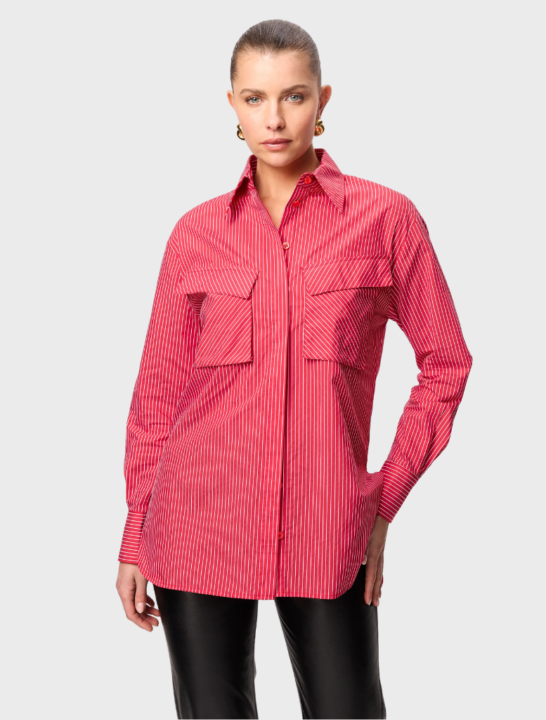 Red striped Tudor shirt displayed on a hanger, showcasing its classic design and vibrant color pattern.