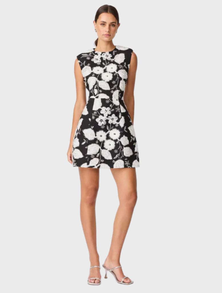 Chic black and white Carol Tulip mini dress showcasing a floral print and a flared design, suitable for various events.