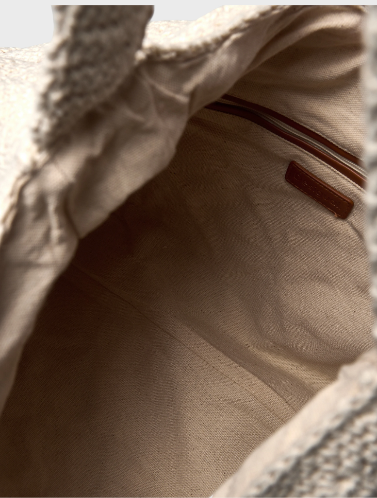 A white Tulum bag featuring a new shape, designed for stylish and functional use.