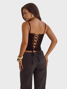 Valerie's black bustier with lace trim, showcasing a sleek silhouette and delicate accents for a chic appearance.