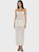 Cream maxi dress with a polka dot pattern, featuring a flowing silhouette and elegant design suitable for various occasions.