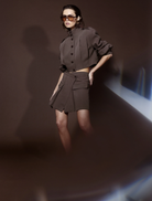 A mocha Vault Mini Skirt laid flat, highlighting its sleek silhouette and soft fabric against a neutral backdrop.