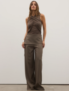 Model wearing a brown top paired with wide-legged Vela Pant in Ash color.