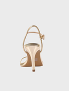 High heel Vicki Sandal in gold metallic leather, designed with a strap and ankle strap for elegance and comfort.