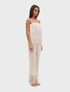 The Visions Lace Pant in buttercream offers a slim silhouette, scalloped waistband, and sheer lace hem for a refined appearance.