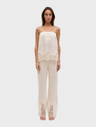 Visions Lace Pant in buttercream features a slim fit, scalloped waistband, and sheer lace panel hem for a delicate look.