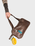 Brown leather handbag featuring two sturdy handles, displayed against a neutral background.
