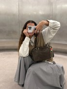  A brown leather handbag with two handles, presented to emphasize its craftsmanship and quality.