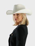 White Addison Cowboy hat displayed on a wooden surface, showcasing its classic western style and design.