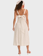 Elegant white midi dress adorned with a dreamy daisy pattern, showcasing a soft, flowing design perfect for any occasion.