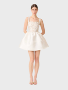 Chic white and gold A-line mini dress, showcasing a tailored bodice and a playful skirt, ideal for summer events.