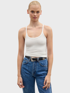 A white Jayla tank top hanging, showcasing its minimalist style and breathable material ideal for casual wear.