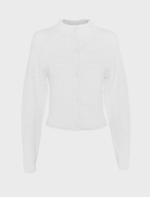 White Carter Cardigan presented on a hanger, highlighting its simple design and versatility for various occasions.