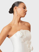 Chic white maxi dress with a strapless silhouette and oleander floral accents, perfect for summer celebrations.