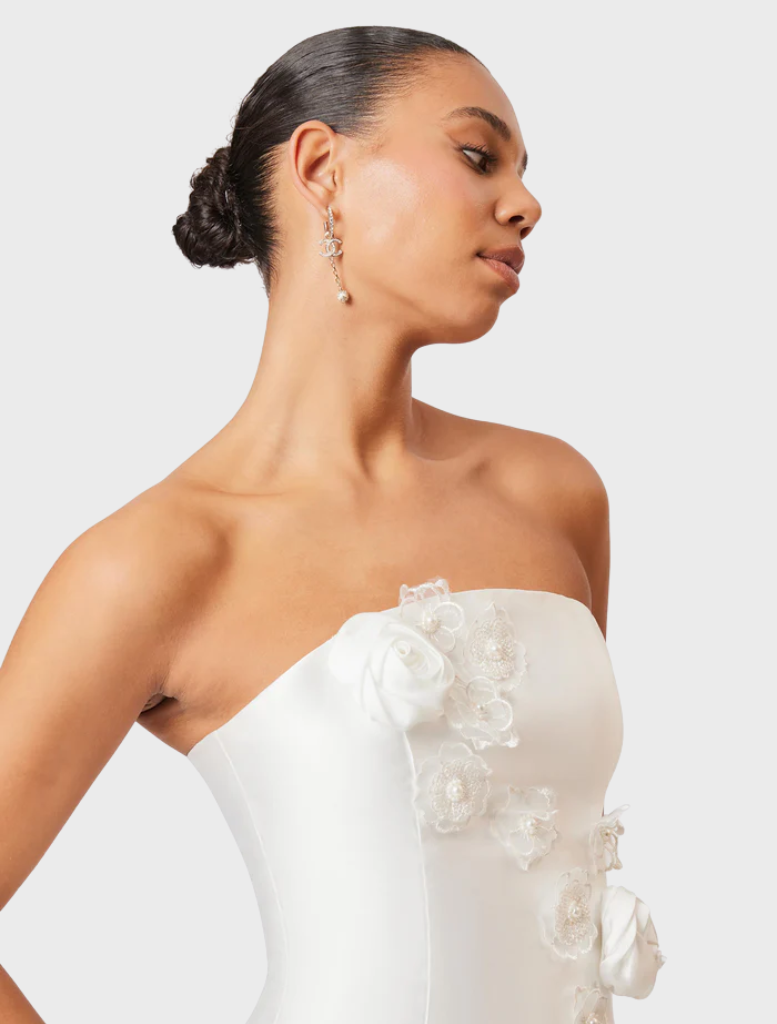 Chic white maxi dress with a strapless silhouette and oleander floral accents, perfect for summer celebrations.