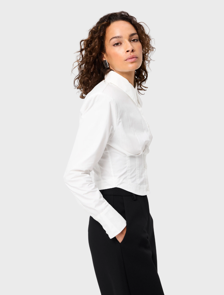 White Darcy shirt displayed on a hanger, featuring a classic collar and button-down front.