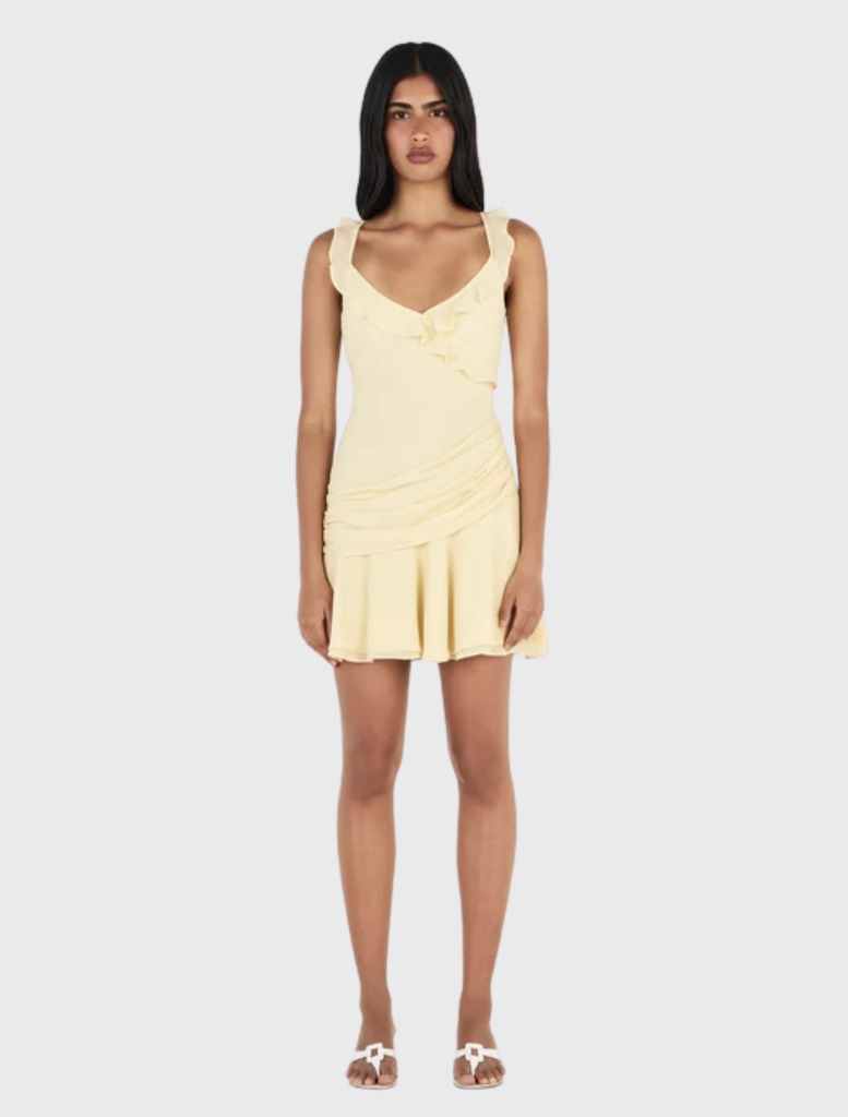 Fitted butter yellow mini dress with ruffles, deep V neckline, open back, and tiered flared skirt.