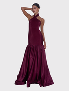 Refined Montaigne Gown in wine, featuring a halter neck, fitted silhouette, and a full-length flared hem for graceful movement.