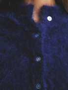 Soft navy Bella Cashmere Cardigan on a hanger, emphasizing its sophisticated look and cozy feel for any occasion.