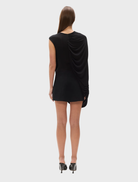 The "Birdie" bodysuit in a dark shade, elegantly draped on a hanger, emphasizing its chic design.