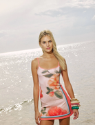 Stylish fitted mini dress in peach adorned with a delicate floral design, perfect for casual or semi-formal occasions.