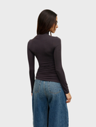 Isley Top in charcoal color, presented on a hanger, illustrating its contemporary design.