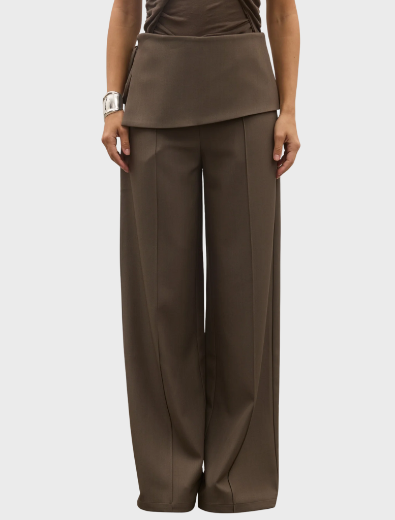 The image shows a model in a brown top and wide-legged Vela Pant, identified as Ash.