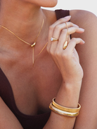 A gold Yunna necklace on a neutral backdrop, emphasizing its sophisticated style and intricate patterns.
