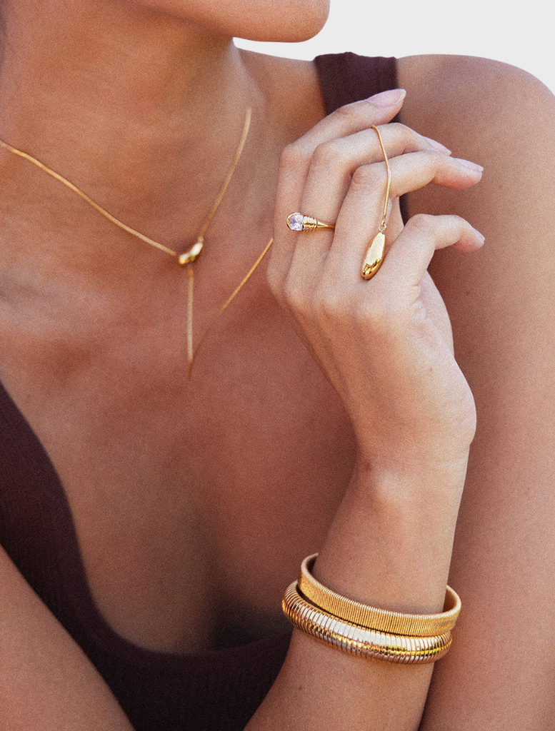 A gold Yunna necklace on a neutral backdrop, emphasizing its sophisticated style and intricate patterns.