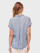 Worn blue wash short sleeve button-down shirt featuring a chest pocket.
