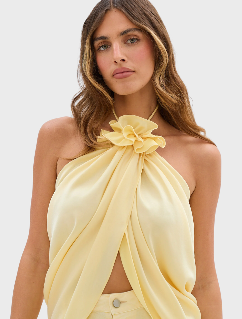 A model features the Celeste Jean Pant in pale yellow, styled with a complementary top for a fashionable appearance.