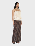 Elegant cream ZOE top hanging, showcasing a minimalist style and smooth fabric ideal for casual wear.